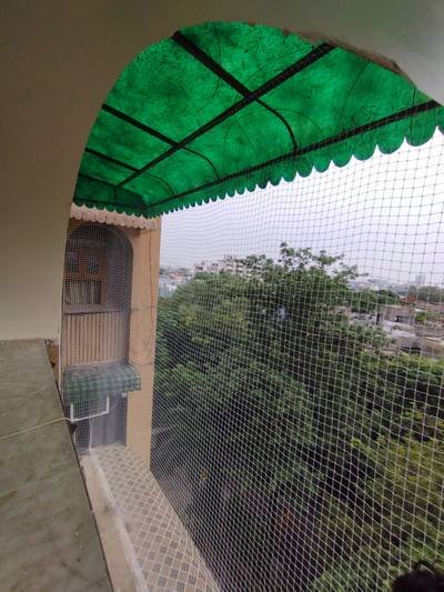 Anti bird net across an arched terrace opening with shade cover above