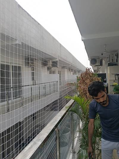 Anti bird net installed along an open corridor passage of a building