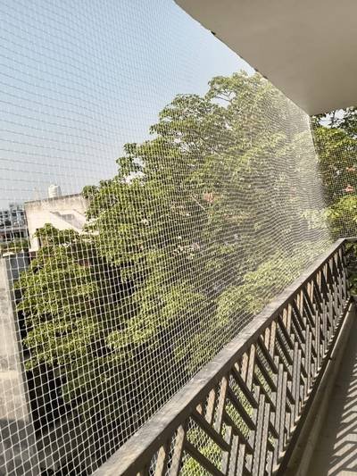 Anti bird net running along an open multi-floor walkway