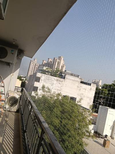 Balcony bird net protecting an air-conditioner unit and ledge