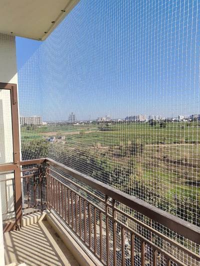 Balcony bird net with an open green outlook beyond the railing