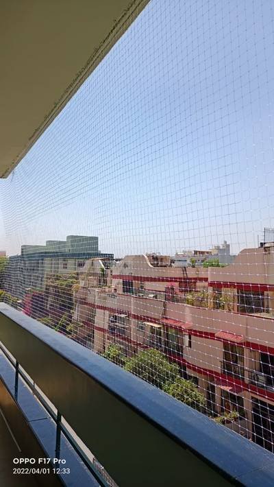 Pigeon net fitted to a balcony railing overlooking city rooftops