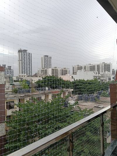 Pigeon net installed on a balcony surrounded by greenery