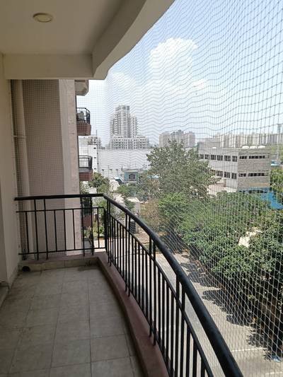 Balcony safety net installed along an open balcony railing