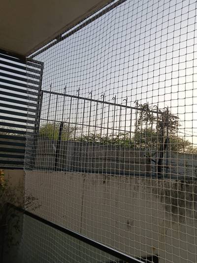 Bird net installed along an open area boundary with trees behind