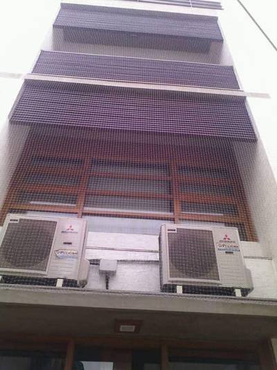 Bird netting protecting building floors above an air-conditioning plant area