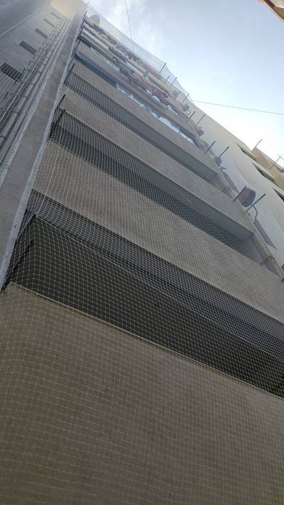 Large-scale bird netting covering a commercial building facade