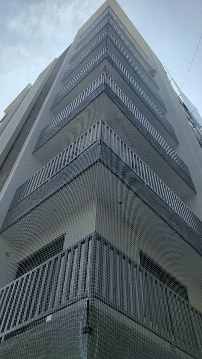 Pigeon protection net covering the full corner elevation of a multi-floor building