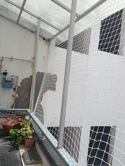 Pigeon protection net covering a building utility shaft and planting area